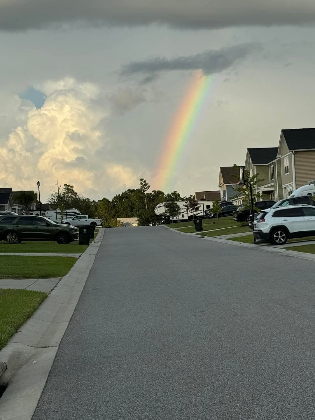 Rainbow descending over a Strawberry Station street after rain